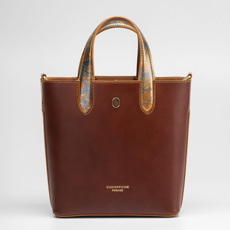 Italian vegetable tanned mini shopping bag leather from one of the most historic Tuscany tannery with light camel patent interior. Handcrafted marbeled details on the handles and the closure flap. Papaya